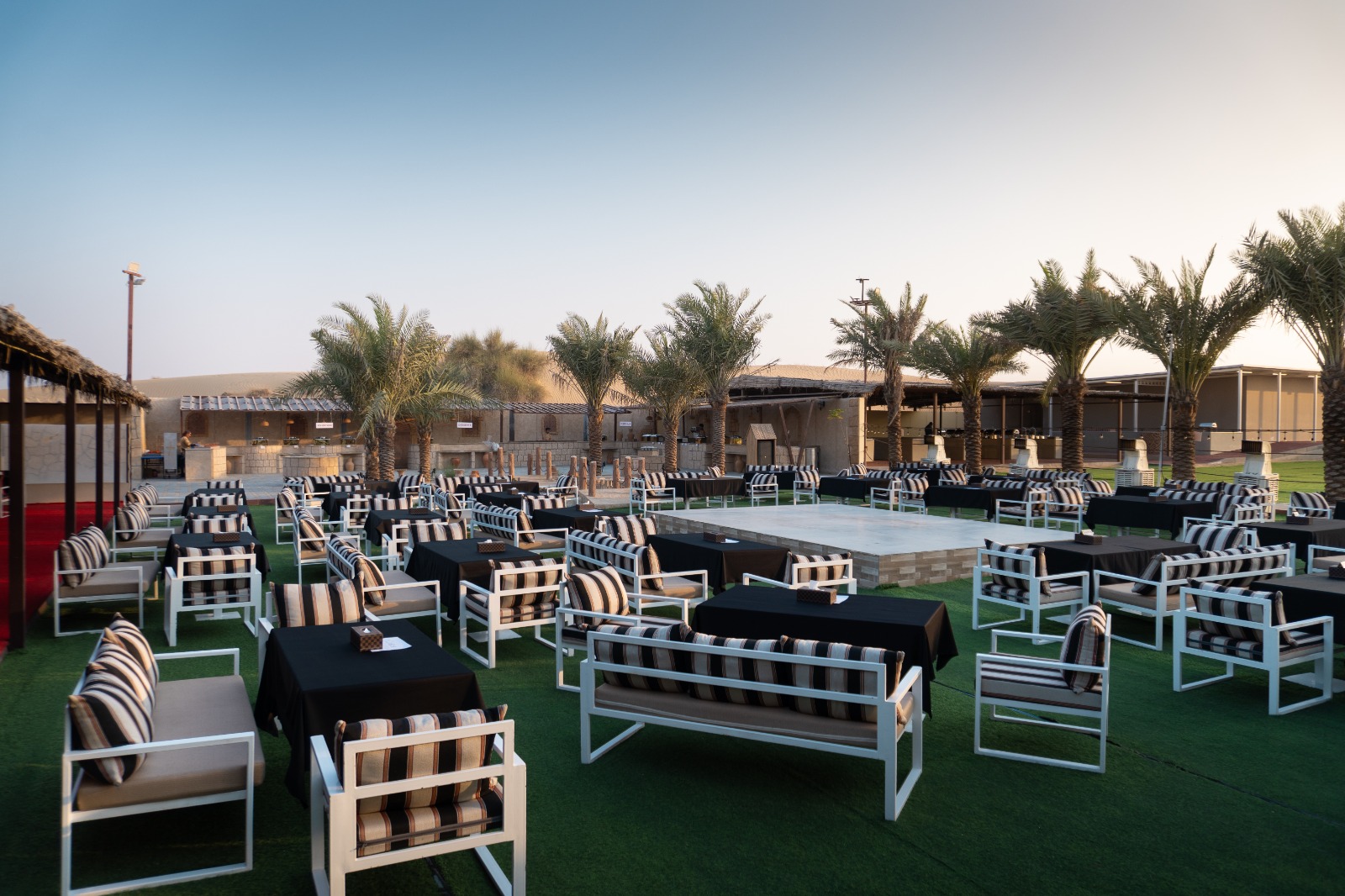 A dedicated waiter serving premium live-cooked BBQ dishes to guests seated in a luxury carpeted lounge during a VIP vs standard safari tour.